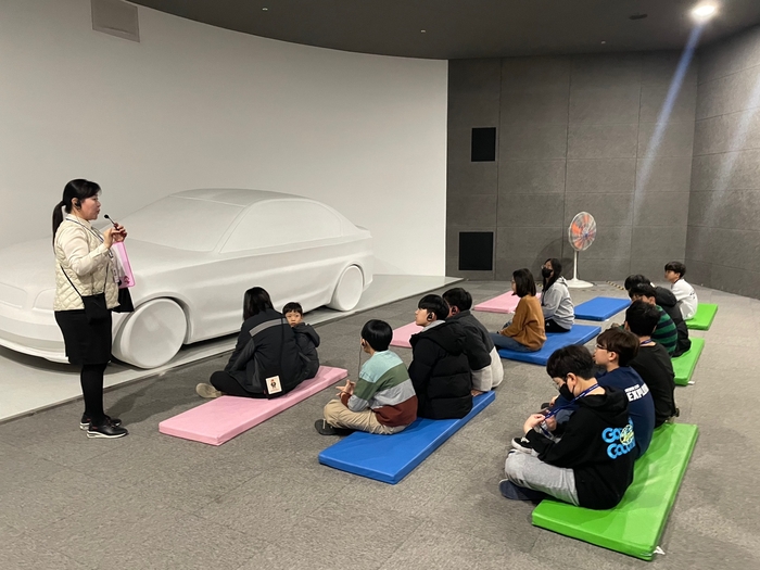 제14회 미래와소프트웨어 꿈찾기 캠프에 참가한 학생들이 국립부산과학관 자동차·항공우주 전시장에서 자동차 구조와 원리를 해설사 통해 설명 듣고 있다.