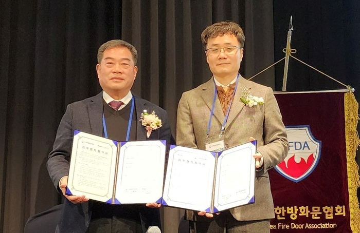 김정효 FITI시험연구원 산업재료본부장과 박영생 대한방화문협회장(왼쪽)이 업무협약을 체결한 후 기념촬영을 하고 있다.