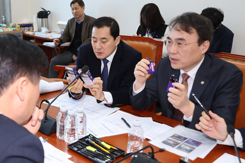 18일 국회 기획재정위원회  경제재정소위원회에서 위원들이 합성니코틴 사용 여부에 따른 액상형 전자담배를 비교하며 담배사업법 개정안을 심의하고 있다. [자료:연합뉴스]