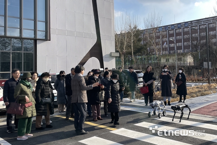 강남구 로봇플러스테스트필드 건물 외부에 조성된 서비스 로봇 테스트베드에서 시민들이 배달 로봇 시연을 보고 있다.