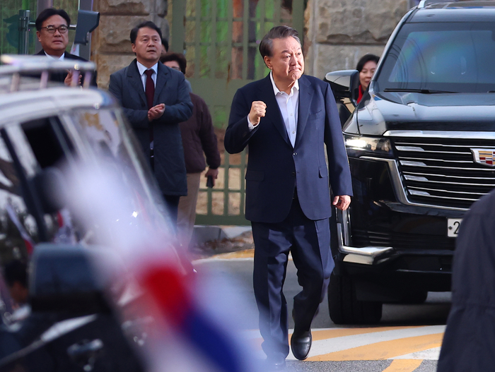 석방된 윤석열 대통령이 8일 경기도 의왕시 서울구치소 앞에서 경호차량에서 내려 지지자들에게 인사하며 주먹을 불끈 쥐어보이고 있다.