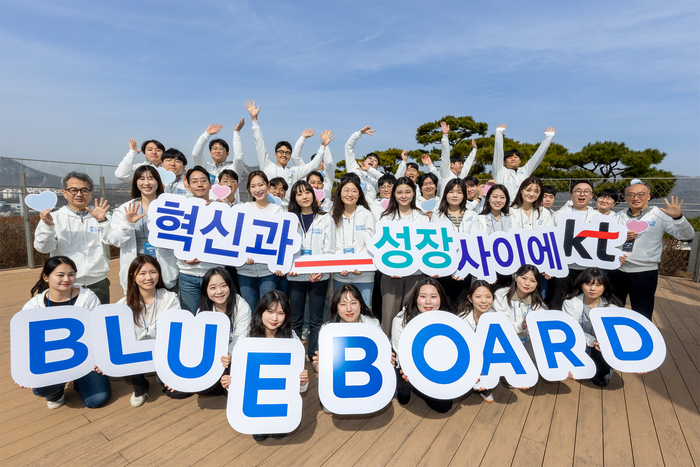 2025년 KT 블루보드로 선발된 직원들이 올해 활동 슬로건인 'KT, 혁신과_성장 사이에'와 함께 기념 촬영을 하고 있다. 기념 촬영에는 KT 경영지원부문장 임현규 부사장(둘째 줄 왼쪽 첫 번째) 등이 참석했다.