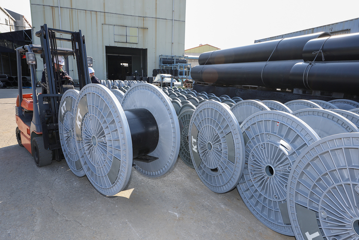 KT 직원이 경기도 김포시에 위치한 아시아플라텍 공장에서 제조된 친환경 보빈을 점검하고 있다.