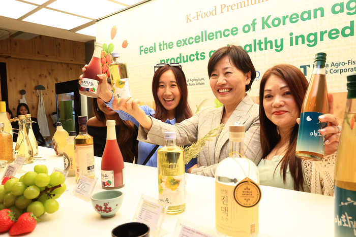 송미령 농림축산식품부 장관이 지난 3월 싱가포르에서 퓨전 외식업체를 방문, 전통주를 소개하며 기념 촬영하고 있다. (사진=농림축산식품부)