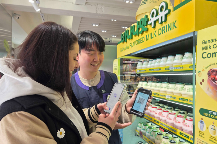 서울 중구 CU 명동역점을 방문한 외국인 고객이 플리토 '챗 트랜스레이션'으로 점포 직원과 소통하고 있다. 플리토 제공