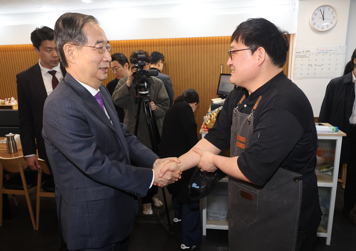한덕수 대통령 권한대행 국무총리가 16일 결식 아동들에게 무료 점심을 제공해온 울산 뚠뚠이 돈가스에서 사장과 인사를 나누고 격려하고 있다. 연합뉴스