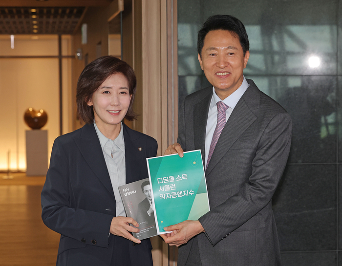 오세훈 서울시장과 회동을 마친 나경원 의원이 16일 서울시청에서 오 시장의 배웅을 받으며 시장실을 나서고 있다. 나 의원 손에는 오 시장의 저서 '다시 성장이다'가 들려있다.