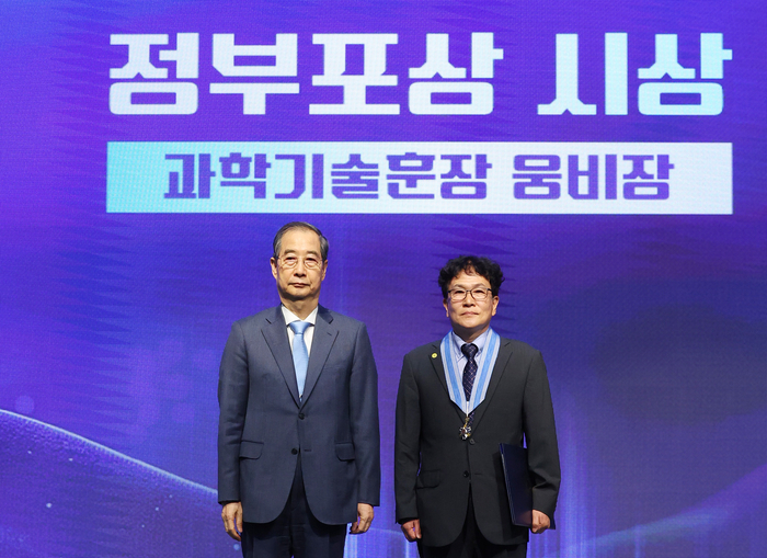 한덕수 대통령 권한대행 국무총리가 21일 서울 강남구 한국과학기술회관에서 열린 '2025년 과학·정보통신의 날 기념식'에서 김양수 한국기초과학지원연구원 책임연구원에게 과학기술훈장 웅비장을 전수한 뒤 기념촬영을 하고 있다. 연합뉴스