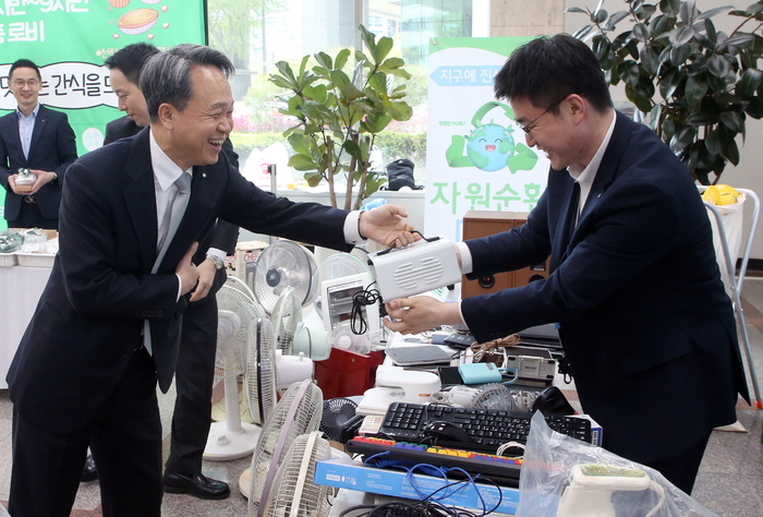 지난 23일부터 사흘간 서울 중구에 위치한 신한은행 본점에서 진행된 '자원순환 Day' 행사에 참석한 진옥동 신한금융그룹 회장(왼쪽)이 가정에서 쓰던 LP플레이어 및 오디오를 기부하고 있다.