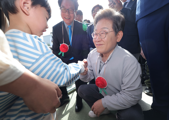 더불어민주당 이재명 대선 후보가 7일 전북 익산시 대한노인회 익산시지회에서 열린 노인회 간담회에 참석하던 중 어린이로부터 카네이션 목걸이를 받고 있다. 연합뉴스