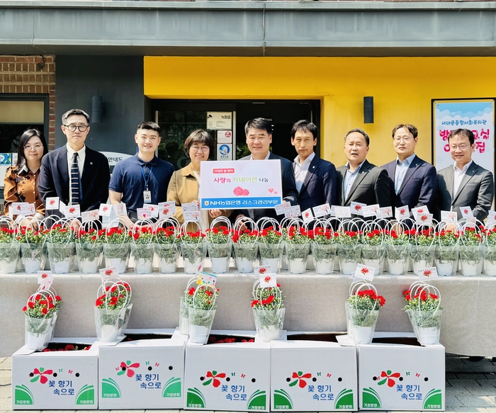 양재영 농협은행 리스크관리부문 부행장(왼쪽 5번째)과 임직원들이 지난 7일 가정의 달을 맞아 서대문종합복지관에 카네이션을 전달하고 있나.