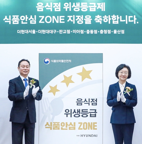 현대백화점 김창섭 부사장(좌)와 오유경 식품의약품안전처장이 식품안심구역 지정식을 진행하고 기념촬영을 하고 있다. 사진=현대백화점.
