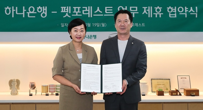 지난 19일 하나은행이 반려동물 장례서비스 제공 업체인 펫포레스트와 수신 VIP 고객 지원을 위한 업무협약을 체결했다. 이날 협약식에 참석한 하나은행 이은정 하나더넥스트본부장(사진 왼쪽)이 펫포레스트 이상흥 대표(사진 오른쪽)와 함께 협약서를 들고 기념 촬영을 하고 있다. 사진=하나은행