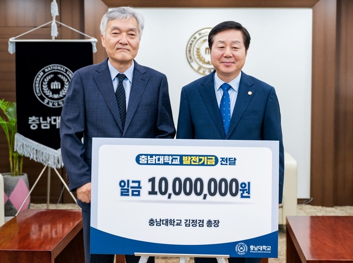 충남대 김정겸 총장(오른쪽)은 민윤기 교학부총장에게 1000만원의 발전기금을 전달하고 기념 촬영했다.
