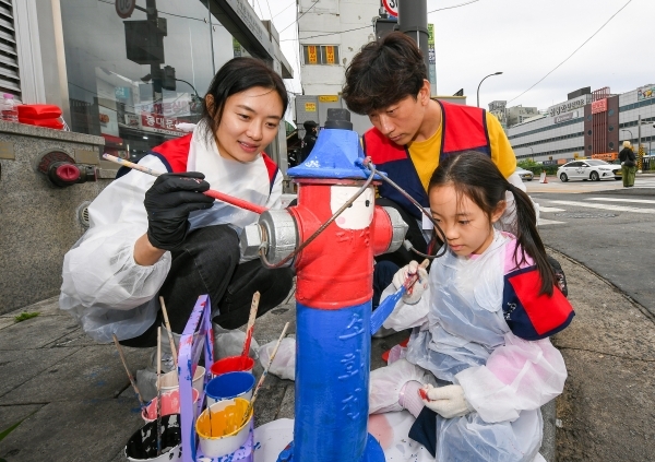 현대모비스 임직원과 가족이 화재 예방과 시인성 향상을 위해 지상식 소화전에 도색 봉사활동을 실시하고 있는 모습