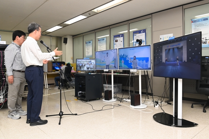 방승찬 원장(왼쪽에서 두번째)이 초저지연 미디어 송수신 기술을 활용해 실시간 원격 게임을 하고 있다.