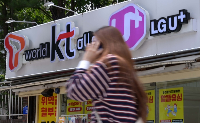 서울 시내 한 이동통신사 판매점 앞을 지나는 시민들.