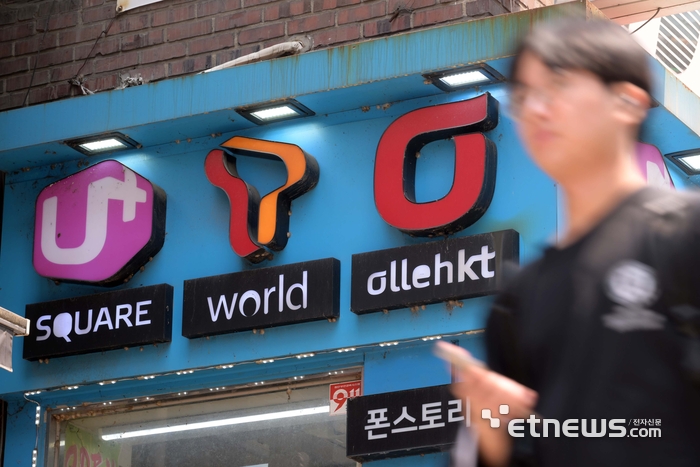 SK텔레콤 유심 해킹 사태가 촉발한 통신사 보조금 경쟁이 치열해지고 있다. 주말 서울 시내 한 이동통신사 대리점 앞을 지나는 시민들. 김민수기자 mskim@etnews.com
