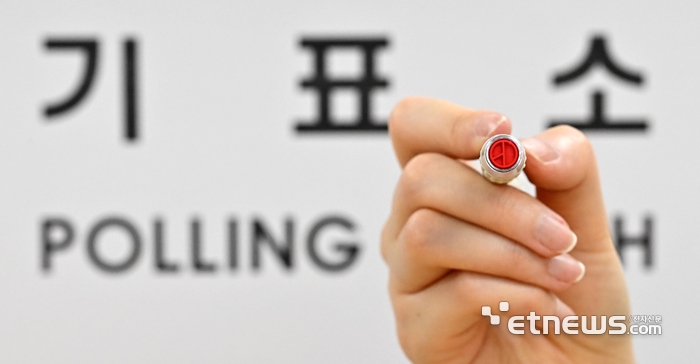 제21대 대통령 선거를 하루 앞둔 2일 서울 용산구 청파도서관에 마련된 청파동 제1투표소에서 관계자가 기표 도장을 들어 보이고 있다.