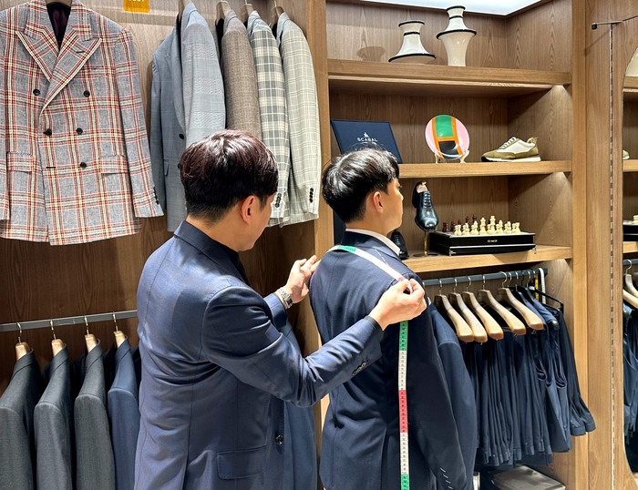 롯데백화점 잠실점 5층 로브테일러 매장에서 정장을 맞추는 고객