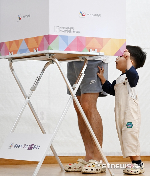 제21대 대통령 선거가 3일 전국 1만 4295개 투표소에서 동시에 진행됐다. 서울 동작구 사당3동주민센터에 마련된 사당제3동제3투표소에서 한 어린이가 아빠의 투표 모습을 바라보고 있다. 이동근기자 foto@etnews.com