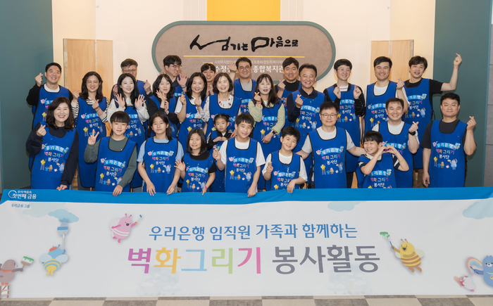 우리은행이 임직원과 가족이 함께 참여하는 'WOORI 가족봉사단'이 전국 사회복지기관에서 '벽화그리기 봉사활동'을 펼쳤다고 8일 밝혔다. 봉사활동에 참여한 임직권과 가족들이 기념사진을 촬영했다. 사진제공=우리은행