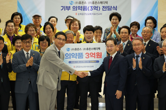 이진석 휴온스메디텍 대표(사진 왼쪽)와 이장균 순복음강남교회 담임목사(사진 오른쪽)가 9일 서울 강남구 순복음강남교회에서 열린 기증식에서 기념사진을 찍고 있다. [사진=휴온스메디텍 제공]