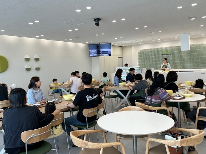 풀무원 두부공장 견학 프로그램에 참가한 고객들이 리뉴얼된 쿠킹 스튜디오에서 체험 담당자의 설명을 듣고 있다.