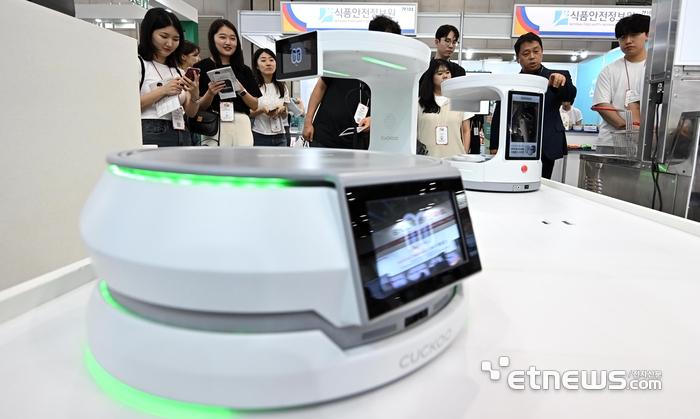 지난해 6월 경기 고양시 킨텍스에서 열린 2025 서울푸드에서 참관객이 쿠쿠홈시스의 서빙로봇을 살펴보고 있다. 이동근 기자 foto@etnews.com