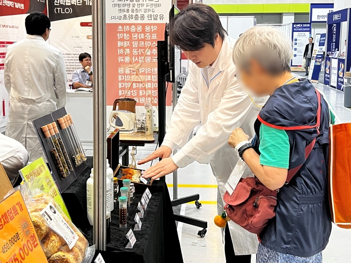 'K-MEX 2025 한의약 및 통합의약 국제산업박람회'에 참가한 바이오아라 관계자가 참관객에게 동충하초를 활용한 제품을 소개하고 있다. 사진=(주)바이오아라