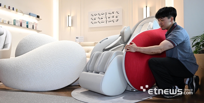 세라젬 서비스매니지먼트팀 AS 매니저가 파우제 M8 Fit 크림화이트 색상의 사이드커버를 루비 레드 색상으로 교체 하고 있다.  이동근기자 foto@etnews.com