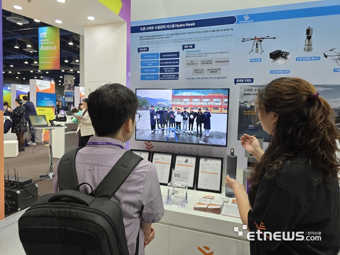 둠둠 부스에서 둠둠 임직원이 참관객에게 드론 기반 수질관리 솔루션 'Hydro Hawk'를 설명하고 있다.