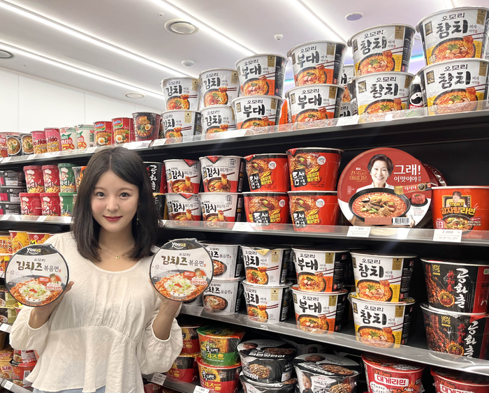 모델이 '오모리김치즈볶음면'을 들고 포즈를 취하고 있다.