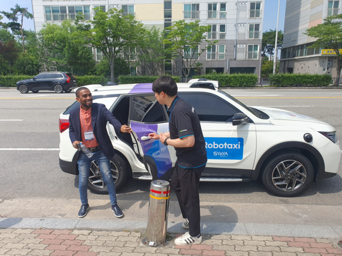 SWM은 지난 25일부터  오는 28일까지김대중컨벤션센터에서 열리는 '2025 광주미래산업엑스포' 기간 동안 자율주행 로보택시 시승행사를 운영중이다.  관람객이 시승후 하차하고 있다.