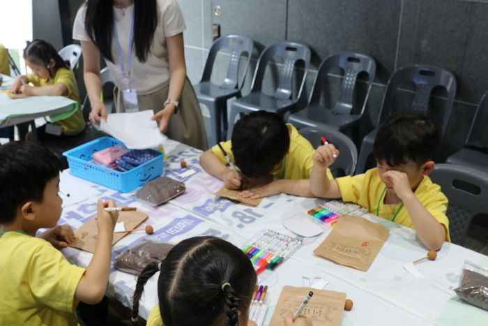 어린이 관람객이 그림봉투 화분 만들기에 참여하고 있는 모습.