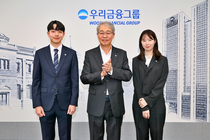 임종룡 우리금융그룹 회장(가운데)이 그룹 새 가족이 된 동양생명·ABL생명 직원에게 디지털 선도의 의미가 담긴 새로운 그룹 보조휘장을 달아주고 기념촬영을 하고 있다.