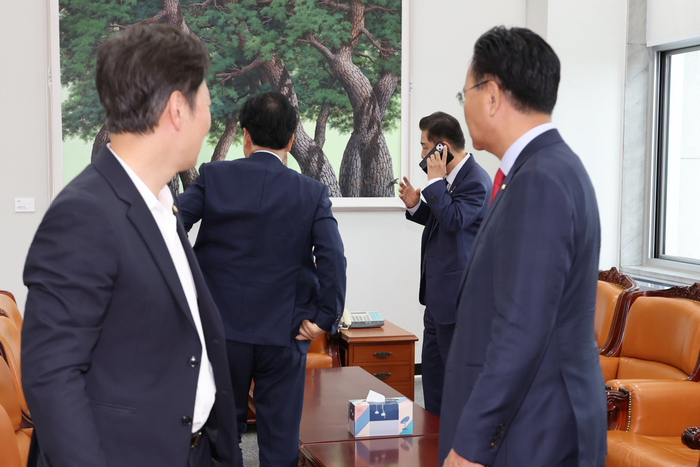 더불어민주당 김병기 당대표 직무대행 겸 원내대표가 1일 서울 여의도 국회에서 추경안 처리 등 의사일정을 논의하기 위해 국민의힘 송언석 비상대책위원장 겸 원내대표와 비공개 회동한 자리에서 급하게 전화통화를 하고 있다.(사진=연합뉴스)