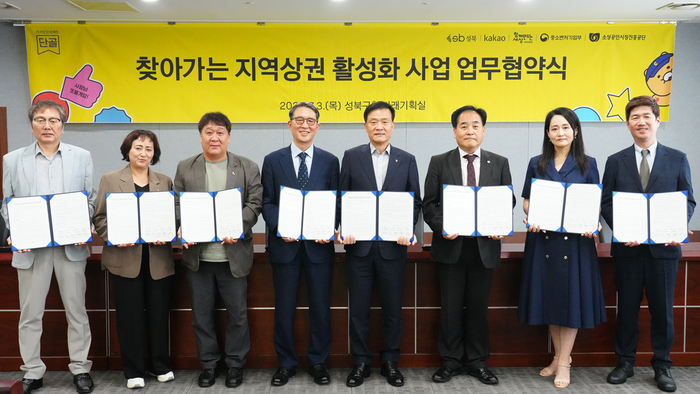 카카오는 지난 3일 서울 성북구와 '찾아가는 지역상권 활성화 사업 업무협약식'을 개최했다. 왼쪽부터 이상문 정릉서경대길 골목형상점가 상인회장, 박시숙 정릉시장 상인회장, 황기욱 장위전통시장 상인회장, 김용덕 사회연대은행 이사장, 이승로 성북구청장, 이정욱 소진공 서울지역본부장, 이남주 성북동길 로컬브랜드육성상권 상인대표, 권대열 카카오 CA 협의체 ESG 위원장이 협약서를 들어보이고 있다. 〈자료 카카오〉