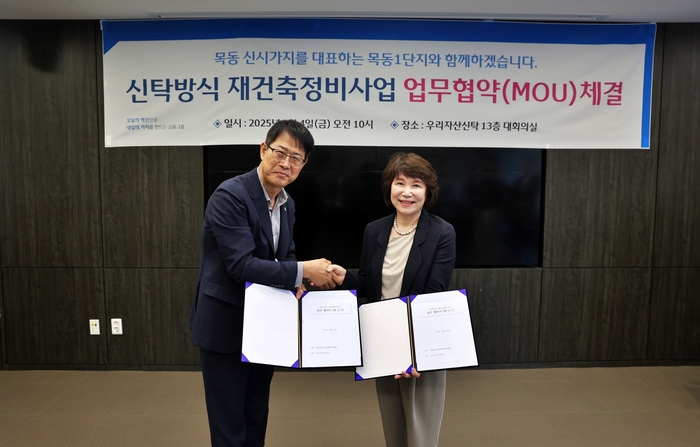 김범석 우리자산신탁 대표(왼쪽)와 정현숙 목동1단지 재건축준비위원장(오른쪽)이 재건축 협력을 다짐하며 악수를 하고있다.