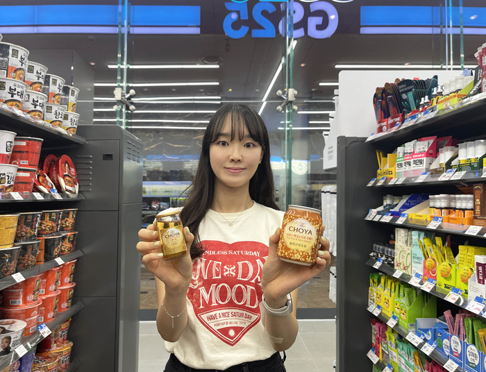GS25에서 모델이 '조야 골든우메후르츠 50㎖'와 '조야 아이스매실&샤과샤베트'를 들고 포즈를 취하고 있다.
