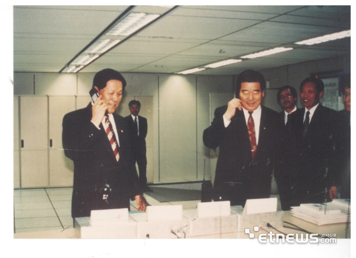 윤동윤 체신부 장관(왼쪽)과 조병일 한국이동통신사장이 1994년 11월 18일 대덕 한국이동통신중앙연구소에서 CDMA이동전화시스템 시험통화를 시도하고 있다. 전자신문DB