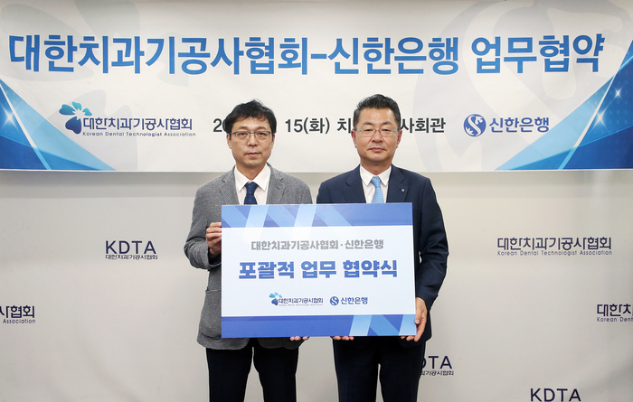 서울시 동대문구 소재 치과기공사회관에서 진행한 '대한치과기공사협회-신한은행' 업무협약식에서 김재민 신한은행 영업추진1그룹장(오른쪽)과 김정민 대한치과기공사협회장이 기념촬영하고 있다.