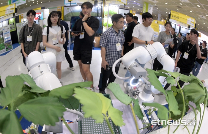 농림축산식품부가 주최한 '제3회 농식품테크 스타트업 창업박람회'가 16일 서울 강남구 코엑스에서 사흘 일정으로 열렸다. 비욘드로보틱스 부스에서 관람객이 3D 비전 인공지능(AI) 기반 과채류 수확 로봇을 살펴보고 있다. 김민수기자 mskim@etnews.com