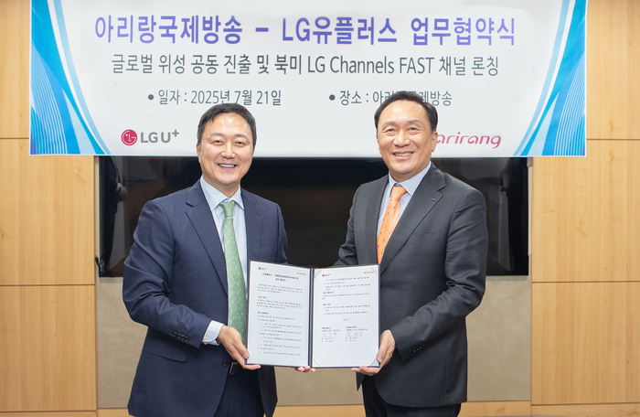 LG유플러스는 아리랑국제방송과 글로벌 방송 유통 확대를 위한 전략적 업무협약(MOU)을 체결하고, 북미 FAST 시장 진출과 아프리카·중남미 지역 위성 송출 협력을 본격화한다고 21일 밝혔다. 사진은 협약식에서 임장혁 LG유플러스 기업고객그룹장(왼쪽)과 김태정 아리랑TV 대표가 사업협력을 다짐하며 기념촬영을 하고 있는 모습.