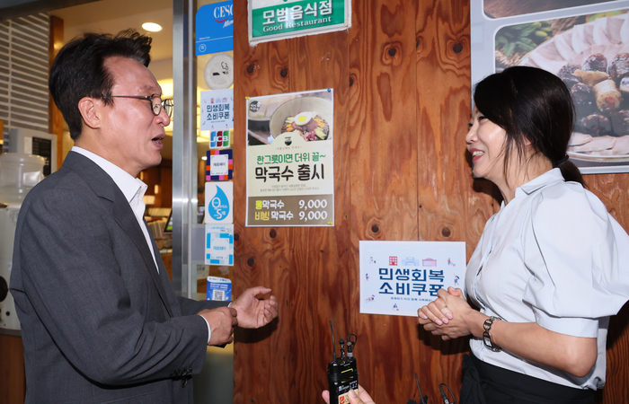 김민석 국무총리가 민생회복 소비쿠폰 신청 시작일인 21일 서울 노원구 한 식당을 찾아 식당 주인과 대화하고 있다. 연합뉴스.