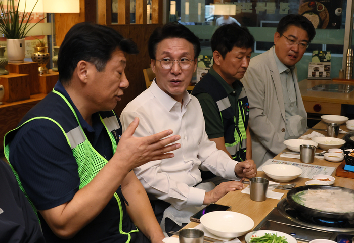 김민석 국무총리가 21일 서울 노원구 한 식당에서 열린 '민생회복 소비쿠폰 계기 환경공무관 조찬'에서 환경공무관들로부터 애로 및 건의사항 등을 청취하고 있다. 연합뉴스.