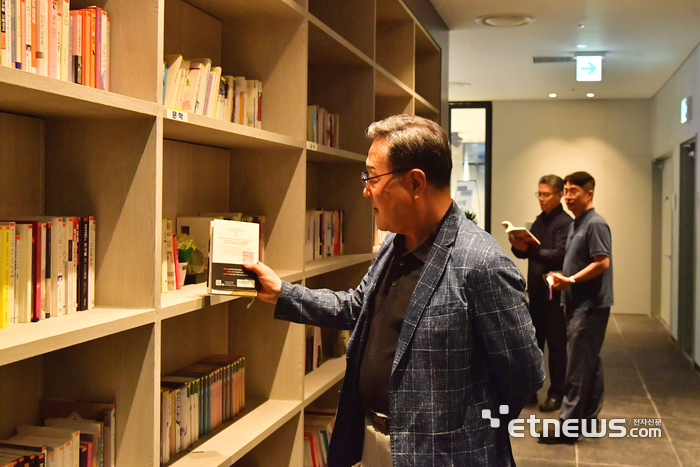 시석중 경기신보 이사장이 최근 GCGF 라운지에 마련된 사내도서관 '지혜의 샘' 개관  행사에 참석해 읽을 책을 고르고 있다.