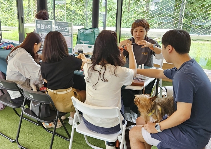 고객들이 놀다가시개! 펫 캠페인에서 비즈 목걸이 만들기에 참여하고 있다.
