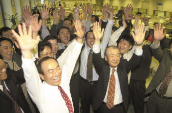 2000년 12월 15일, IMT2000 사업권 획득 소식에 당시 조정남 SK텔레콤 부회장(앞줄 오른쪽) 등 임직원들이 환호하고 있다.