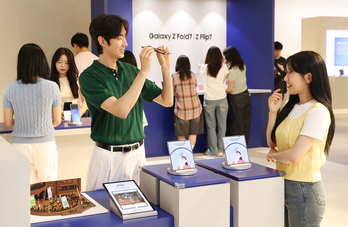 더현대 서울에 오픈한 '갤럭시 스튜디오'에서 방문객들이 '갤럭시 Z 폴드7'의 초슬림 두께를 체험하는 모습.